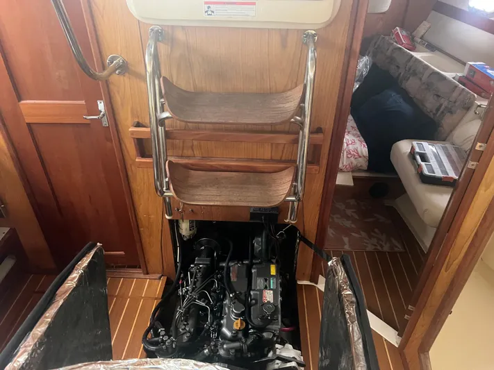 "helluva" Yacht Photos Pics Engine compartment of a 2000 Hunter 410 sailboat with wooden interior and seating area.