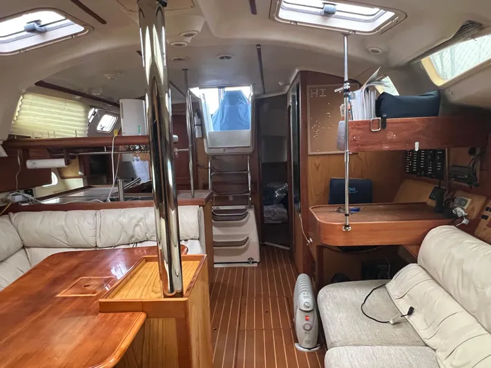 "helluva" Yacht Photos Pics Interior of a 2000 Hunter 410 sailboat with wood finishes and seating area.