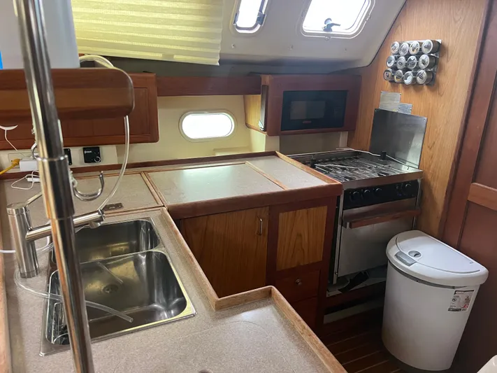 "helluva" Yacht Photos Pics Kitchen area in a 2000 Hunter 410 sailboat with sink, stove, and storage.