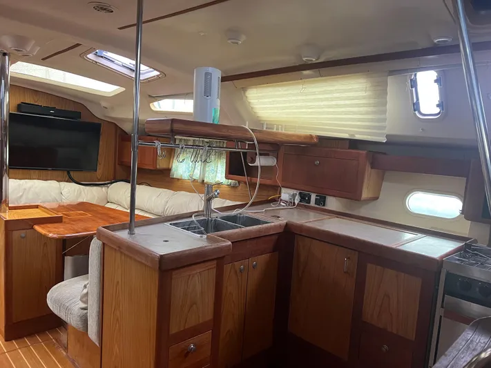 "helluva" Yacht Photos Pics Interior of 2000 Hunter 410 sailboat with wood cabinetry and seating area.