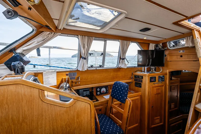 Emeritus Yacht Photos Pics Cozy interior of 2000 Nauticat 35 Pilot House with wooden finish and ocean view.