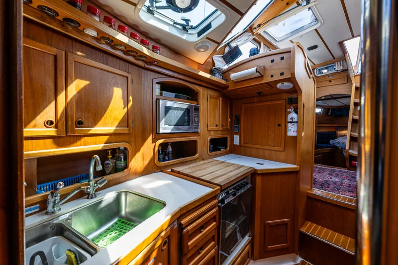 Emeritus Yacht Photos Pics Cozy Nauticat 35 Pilot House kitchen with wooden cabinetry and modern appliances, year 2000 model.