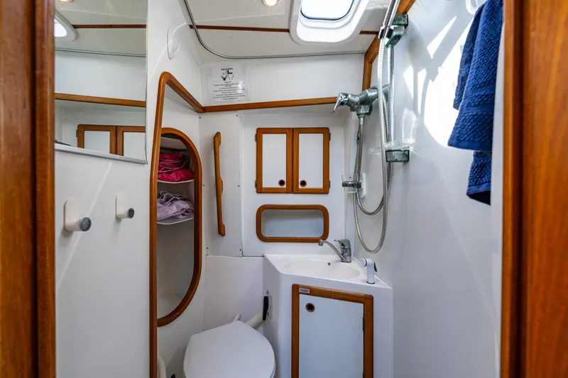 Emeritus Yacht Photos Pics Bathroom interior of 2000 Nauticat 35 Pilot House with shower and wooden accents.