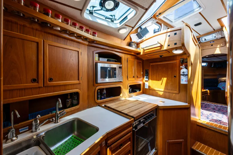 Emeritus Yacht Photos Pics Nauticat 35 Pilot House 2000 interior with wooden cabinetry and modern kitchen amenities.