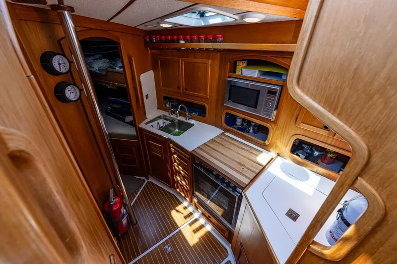 Emeritus Yacht Photos Pics Nauticat 35 Pilot House 2000 interior with wooden cabinetry, kitchen appliances, and nautical decor.