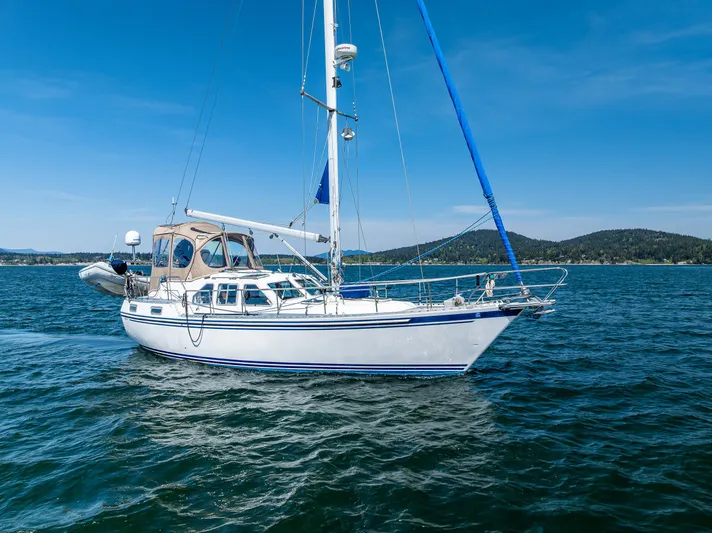 Emeritus Yacht Photos Pics Sailing yacht Nauticat 35 Pilot House 2000 on open water under clear blue sky.