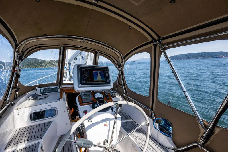 Emeritus Yacht Photos Pics Pilot house interior of 2000 Nauticat 35 sailboat with navigation equipment and scenic ocean view.