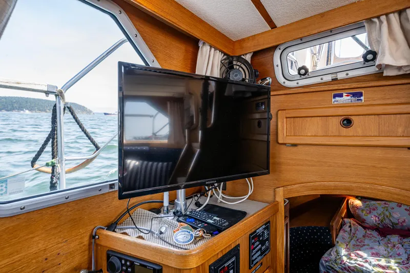 Emeritus Yacht Photos Pics Nauticat 35 Pilot House 2000 interior with TV, wooden cabinetry, and ocean view.