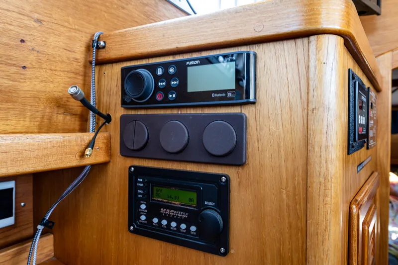 Emeritus Yacht Photos Pics Wooden control panel in a 2000 Nauticat 35 Pilot House with radio and navigation equipment.