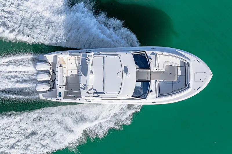 Conspirasea Yacht Photos Pics 2021 Pursuit DC 365 Dual Console boat cruising on turquoise water, aerial view.
