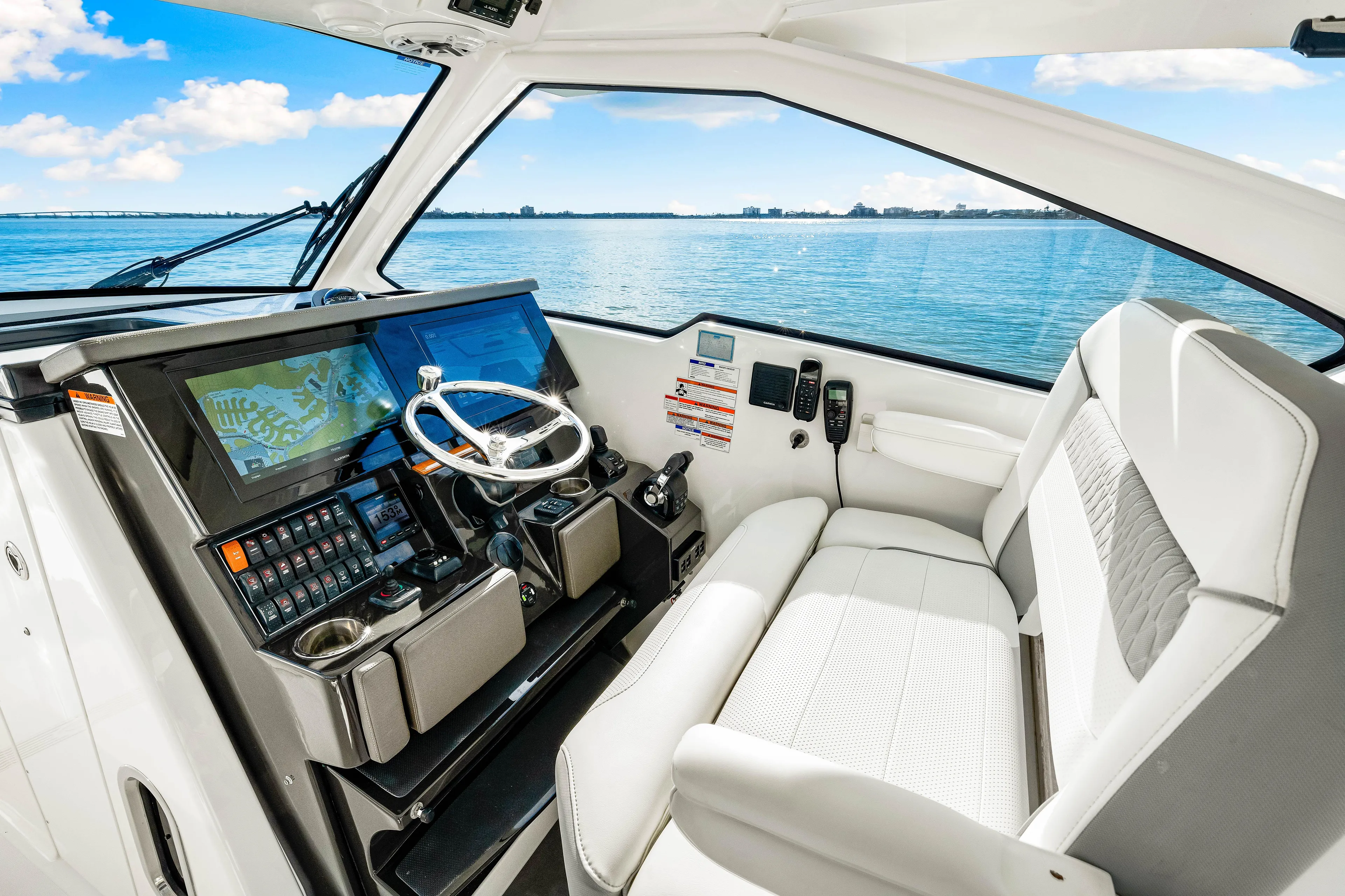 Conspirasea Yacht Photos Pics 2021 Pursuit DC 365 Dual Console interior with modern helm and seating, overlooking serene waters.