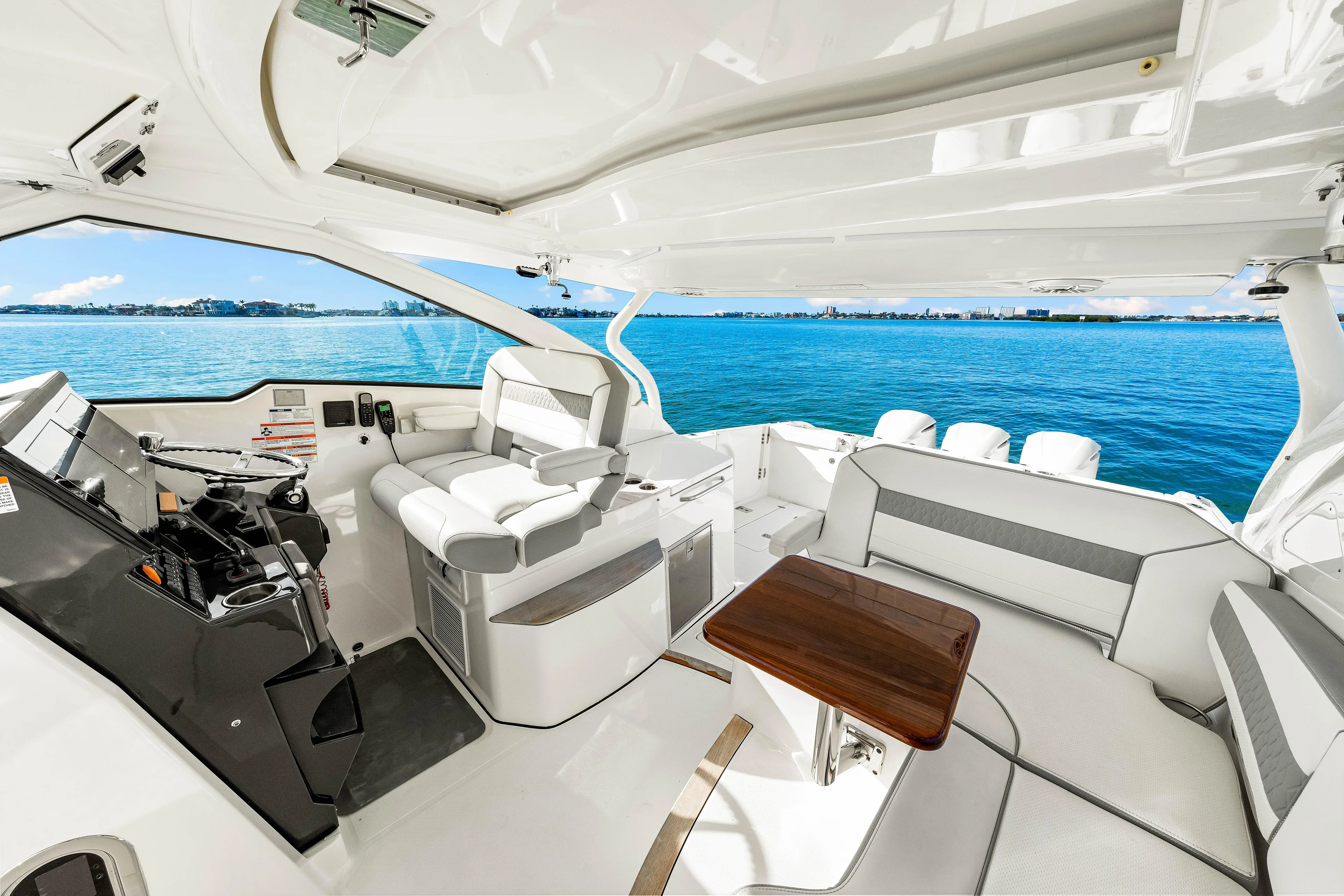 Conspirasea Yacht Photos Pics 2021 Pursuit DC 365 Dual Console boat interior with seating and helm, overlooking blue water.
