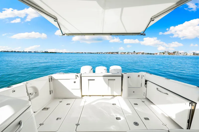 Conspirasea Yacht Photos Pics 2021 Pursuit DC 365 Dual Console boat with spacious deck overlooking serene blue waters.