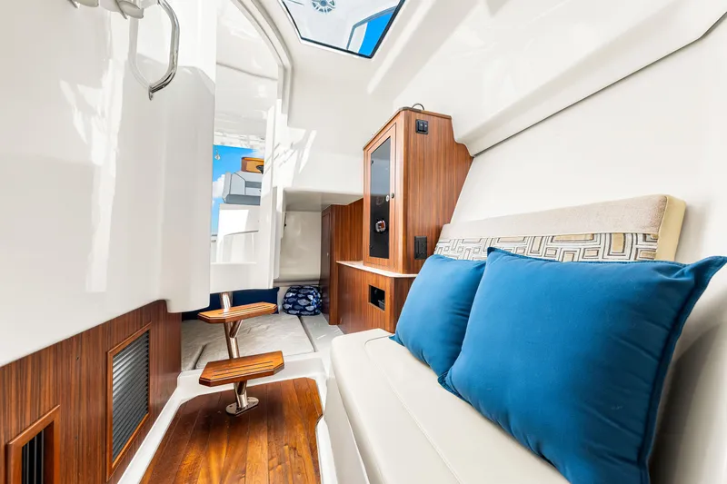 Conspirasea Yacht Photos Pics 2021 Pursuit DC 365 Dual Console interior with wood accents and blue cushions.
