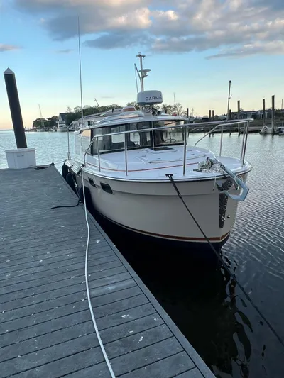 Yacht Photos Pics 2023 Ranger Tugs R-27 docked at a marina under a cloudy sky.