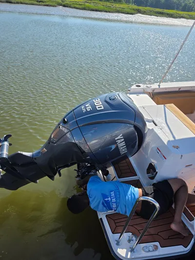  Yacht Photos Pics Man inspecting Yamaha outboard motor on 2023 Ranger Tugs R-27 boat.