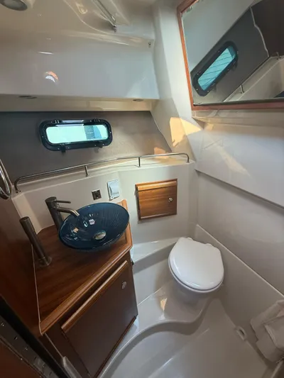  Yacht Photos Pics 2023 Ranger Tugs R-27 boat bathroom with modern sink, toilet, and wood accents.