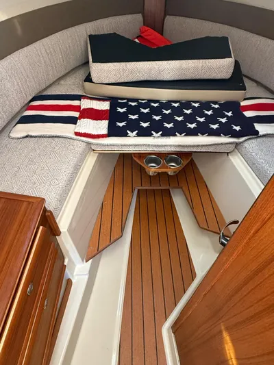  Yacht Photos Pics 2023 Ranger Tugs R-27 cabin interior with wooden flooring and cozy bedding.