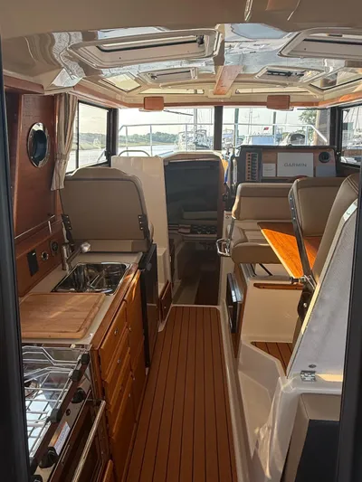  Yacht Photos Pics 2023 Ranger Tugs R-27 interior with kitchen, seating, and navigation equipment.