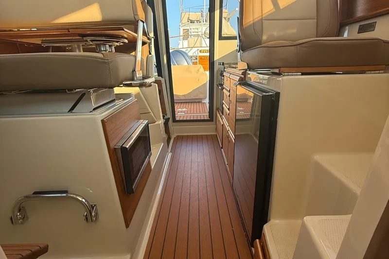  Yacht Photos Pics Interior of 2023 Ranger Tugs R-27, featuring wood flooring and modern seating.