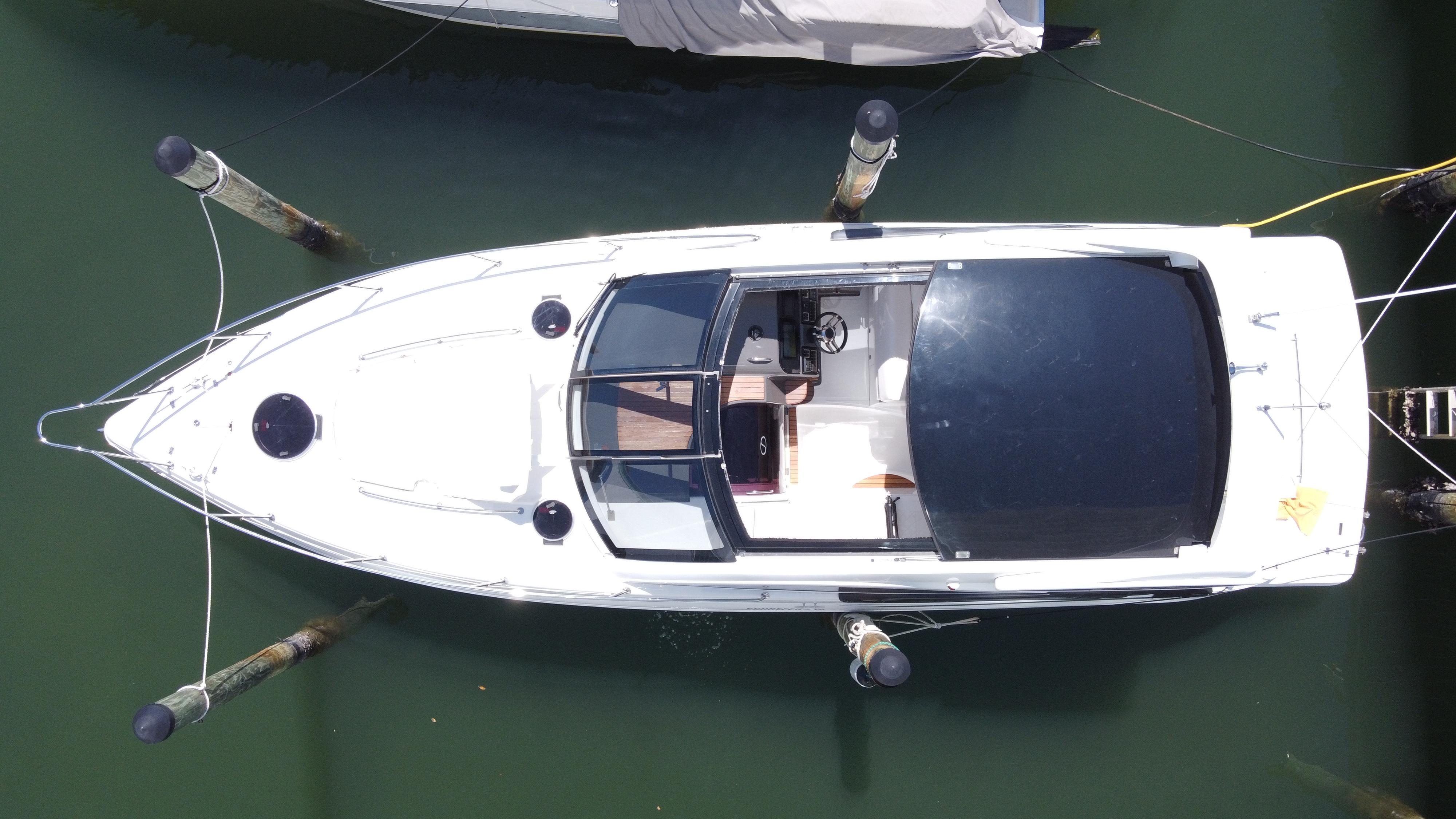 2023 Schaefer 375 HT boat docked, aerial view, sleek design, white hull, black canopy.