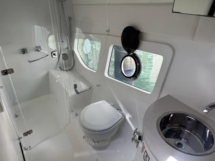  Yacht Photos Pics Modern bathroom in 2023 Schaefer 375 HT yacht, featuring shower, toilet, and sink.