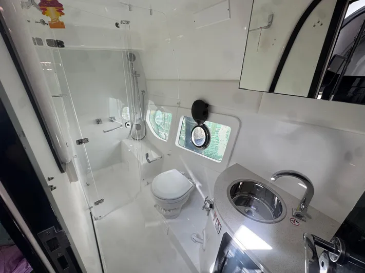  Yacht Photos Pics Modern bathroom in 2023 Schaefer 375 HT yacht, featuring shower, toilet, and sink.