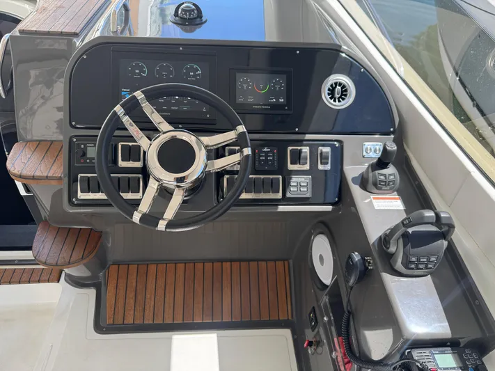  Yacht Photos Pics 2023 Schaefer 375 HT yacht helm with modern controls and wooden accents.