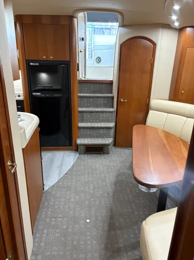 White Lightning Yacht Photos Pics Interior of 2003 Cruisers Yachts 4270 Express, featuring stairs, seating, and wooden cabinetry.