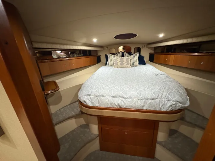 White Lightning Yacht Photos Pics Luxurious cabin interior of 2003 Cruisers Yachts 4270 Express with cozy bedding and wooden accents.