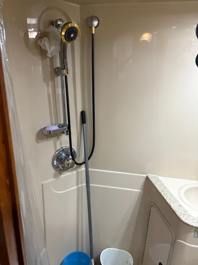 White Lightning Yacht Photos Pics Shower area in 2003 Cruisers Yachts 4270 Express, featuring modern fixtures and cleaning supplies.