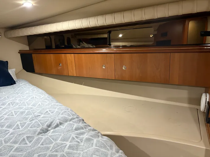 White Lightning Yacht Photos Pics Interior cabin of 2003 Cruisers Yachts 4270 Express with wooden cabinets and bed.