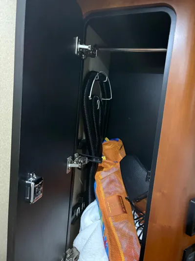 White Lightning Yacht Photos Pics Storage compartment inside 2003 Cruisers Yachts 4270 Express, containing various items and equipment.