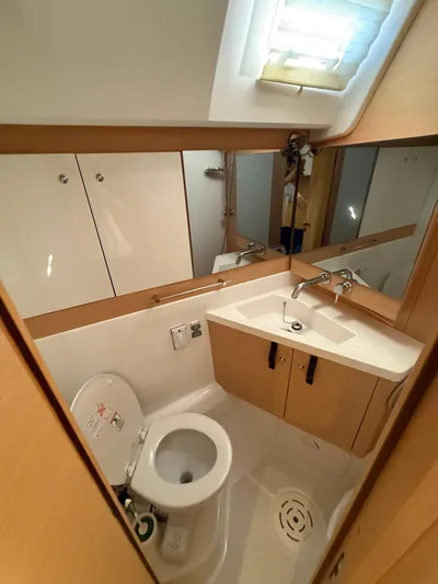 Padraigin II Yacht Photos Pics Compact bathroom in 2016 Jeanneau Yachts 58, featuring toilet, sink, and storage cabinets.