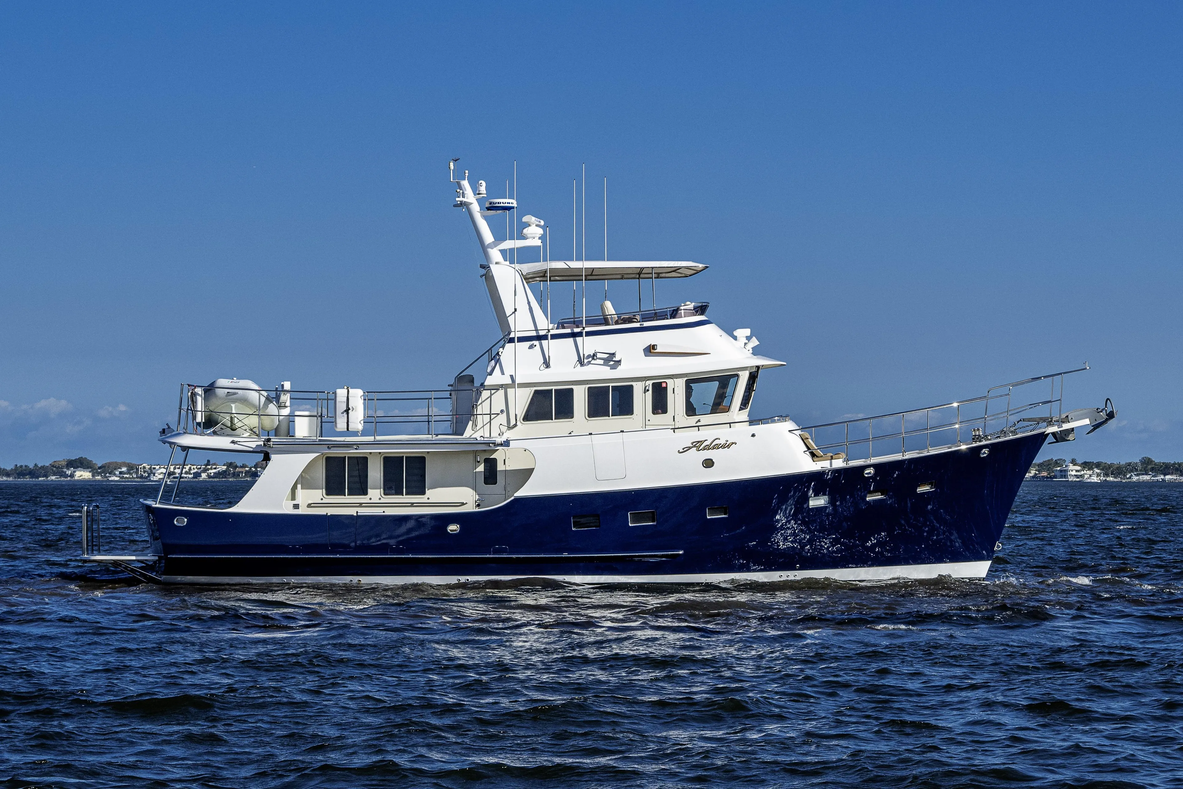 2017 Kadey-Krogen 58EB yacht cruising on open water under clear blue skies.