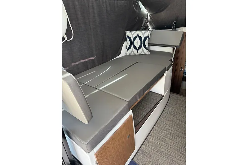  Yacht Photos Pics Interior of 2023 Beneteau Antares 9 with cushioned seating and decorative pillow.