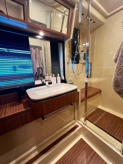 Obsession Yacht Photos Pics Luxurious bathroom in 2015 Azimut Magellano 53 yacht with modern fixtures and wood accents.