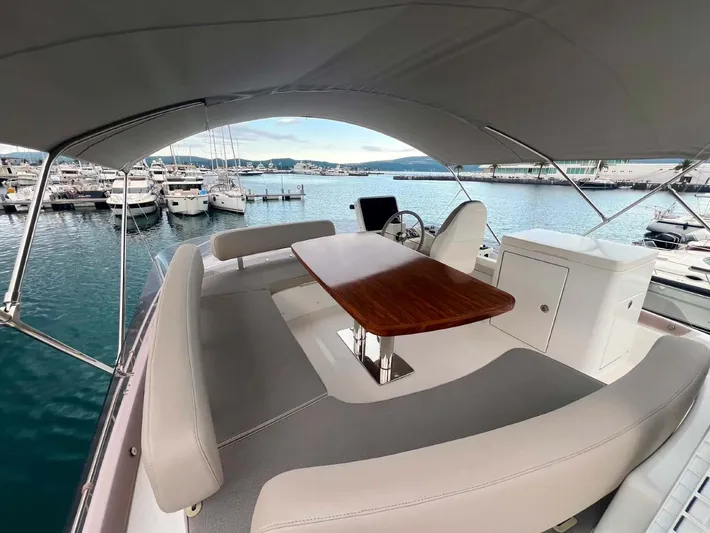 Obsession Yacht Photos Pics Flybridge of 2015 Azimut Magellano 53 yacht with seating and table, docked at marina.