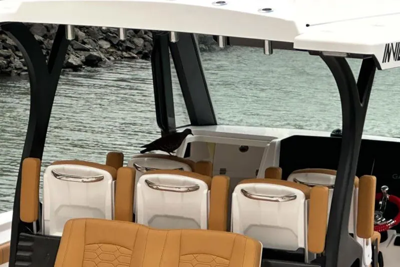  Yacht Photos Pics 2026 MVI Invicta 30CC boat interior with bird perched on seat by the water.