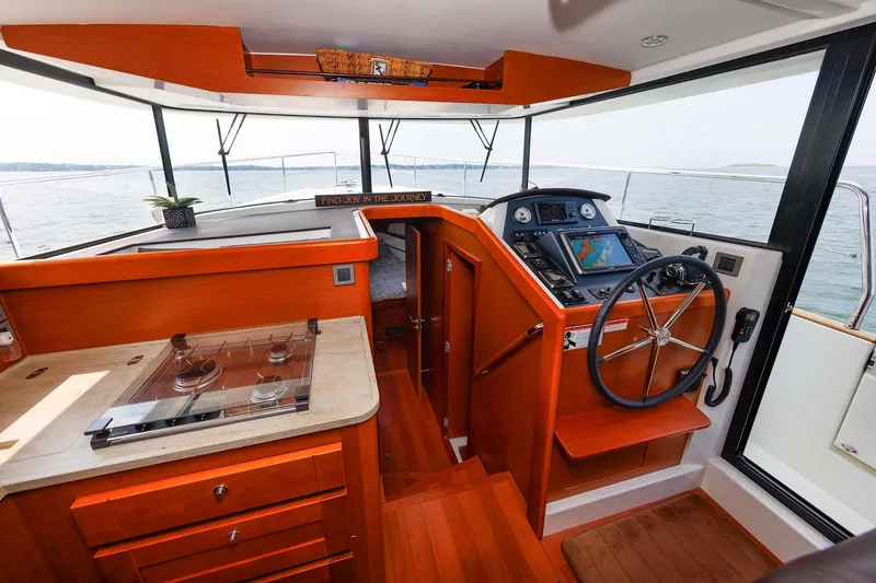 Gotali Yacht Photos Pics 2016 Beneteau Swift Trawler 44 interior with helm, wooden cabinetry, and sea view.