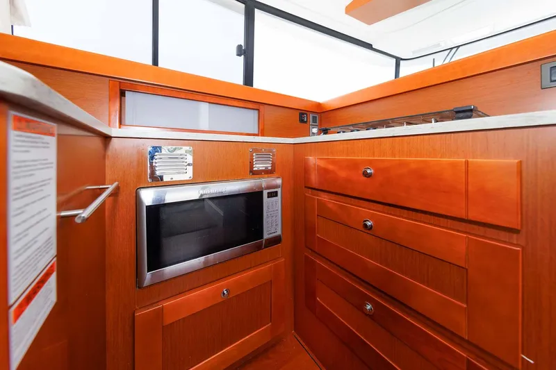 Gotali Yacht Photos Pics Interior of 2016 Beneteau Swift Trawler 44, featuring wooden cabinetry and built-in microwave.