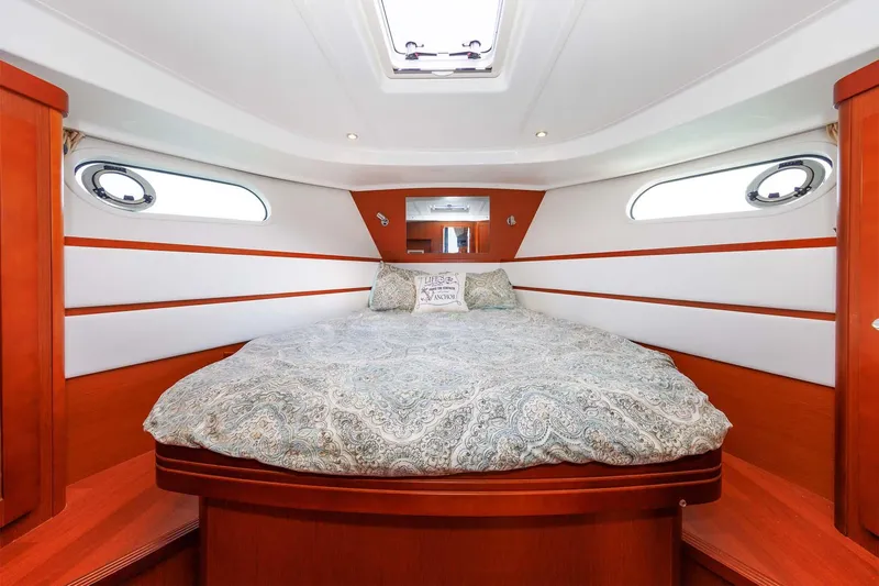 Gotali Yacht Photos Pics Interior cabin of 2016 Beneteau Swift Trawler 44 with cozy bed and porthole windows.