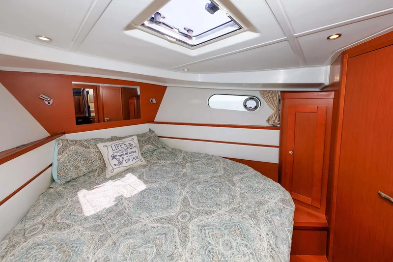 Gotali Yacht Photos Pics 2016 Beneteau Swift Trawler 44 cabin interior with cozy bed and wooden accents.