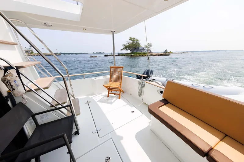 Gotali Yacht Photos Pics 2016 Beneteau Swift Trawler 44 deck with seating, overlooking serene waters and distant islands.