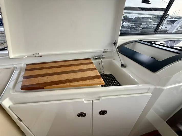  Yacht Photos Pics 2013 Beneteau Gran Turismo 34 yacht interior with sink and wooden cutting board.
