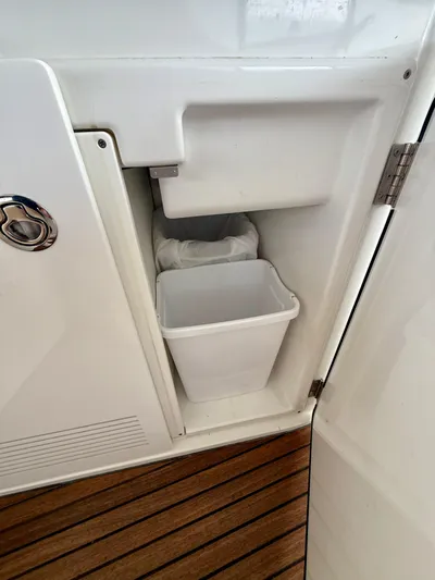  Yacht Photos Pics Beneteau Gran Turismo 34, 2013 model, interior storage compartment with trash bin on wooden floor.