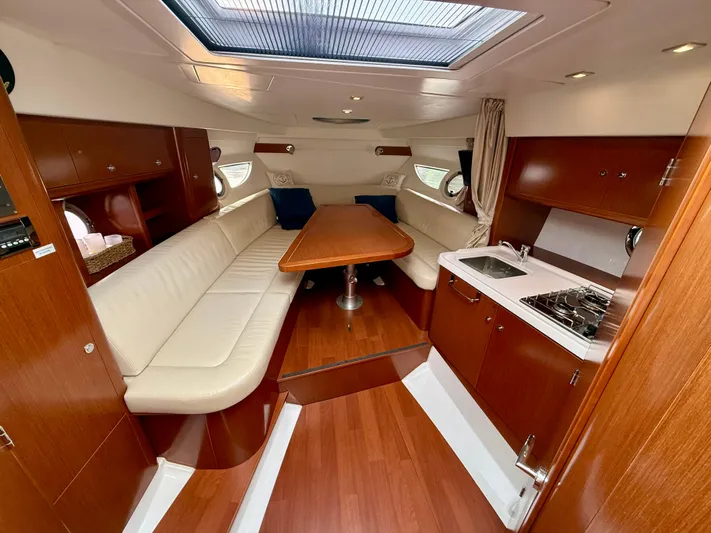  Yacht Photos Pics 2013 Beneteau Gran Turismo 34 interior with wood finish, seating, and kitchenette.