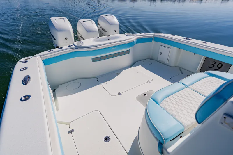  Yacht Photos Pics 2015 Yellowfin 39 Offshore boat interior with triple engines, featuring white and blue seating.
