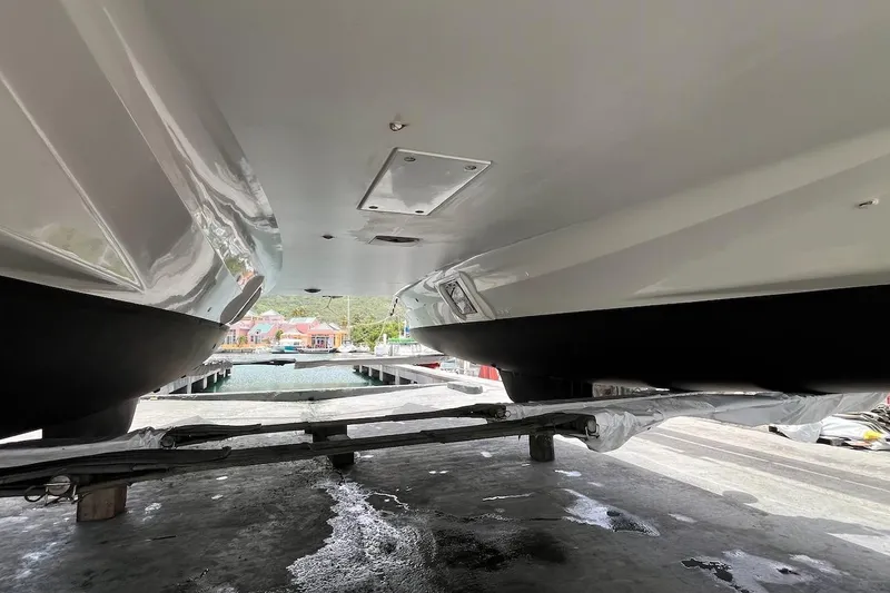 Honu Kai Yacht Photos Pics 2023 Fountaine Pajot Catamaran Astrea 42 hulls in dry dock, showcasing sleek design.