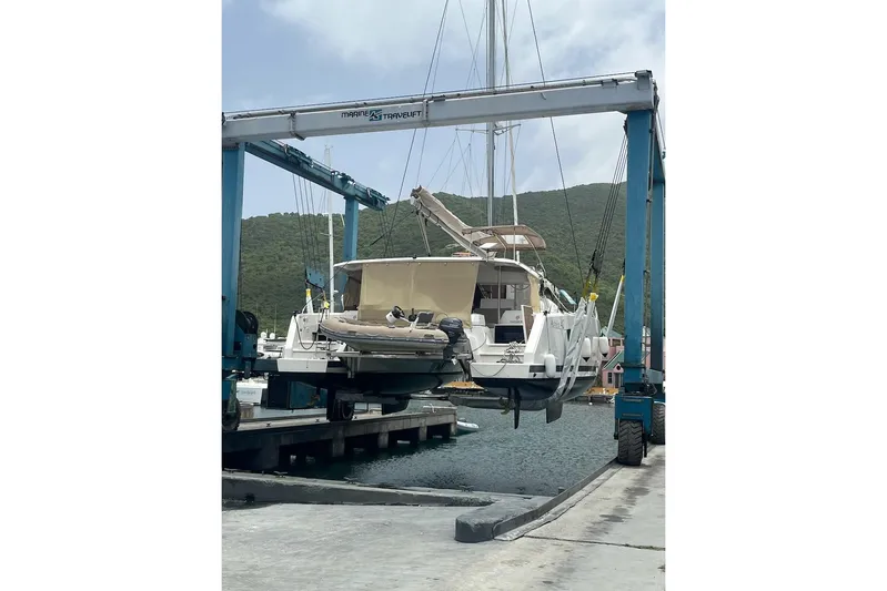 Honu Kai Yacht Photos Pics 2023 Fountaine Pajot Catamaran Astrea 42 being lifted at marina dock.